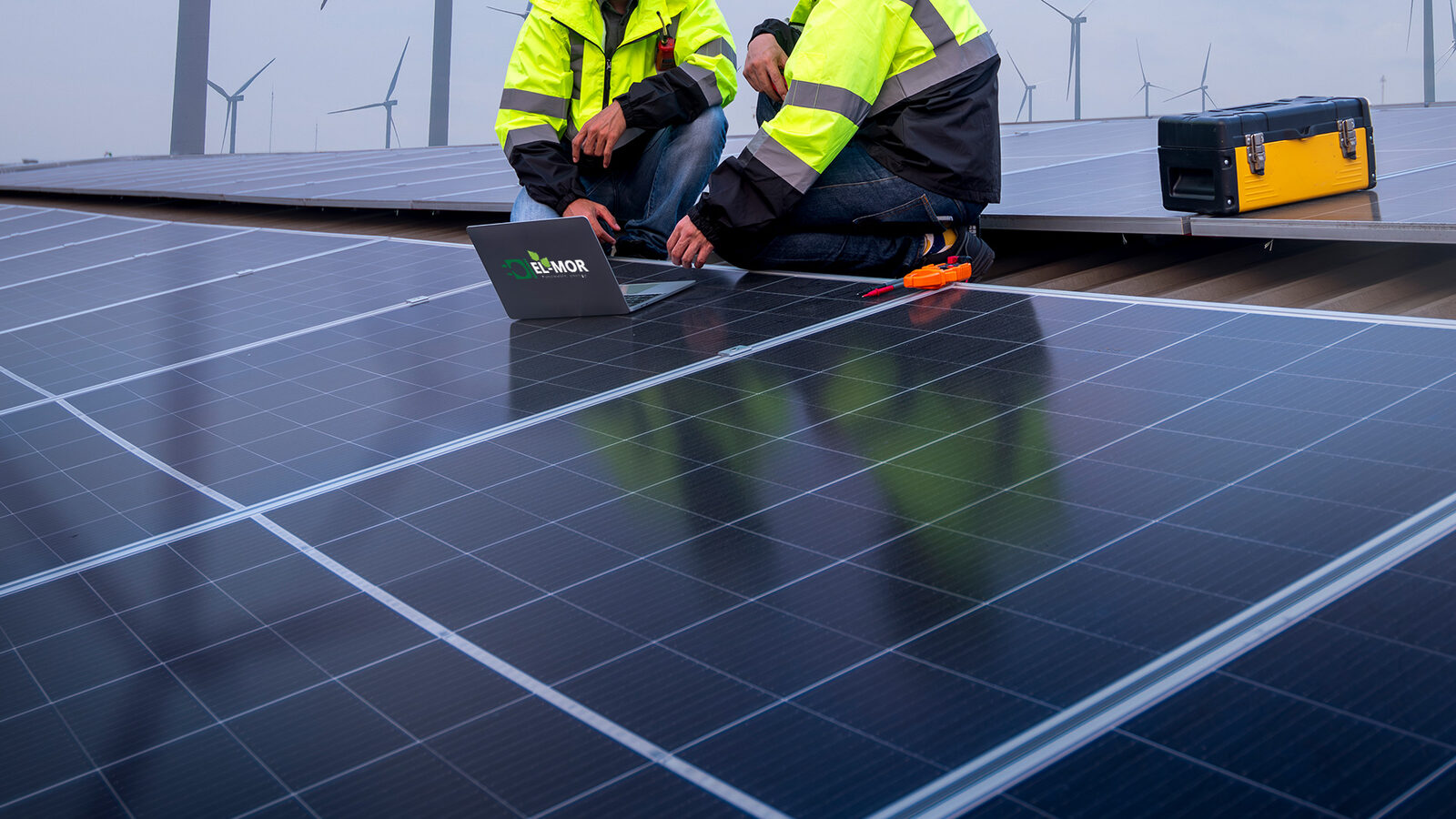 El-Mor technicians monitoring solar panels with a laptop